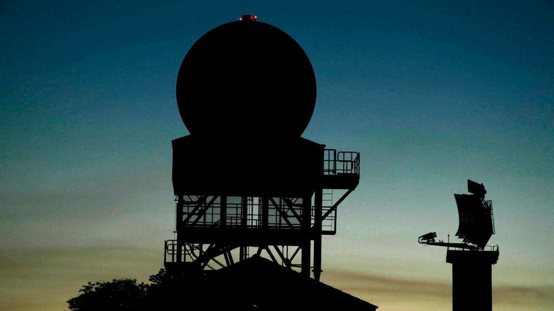 Radar station silhouette against a night sky.