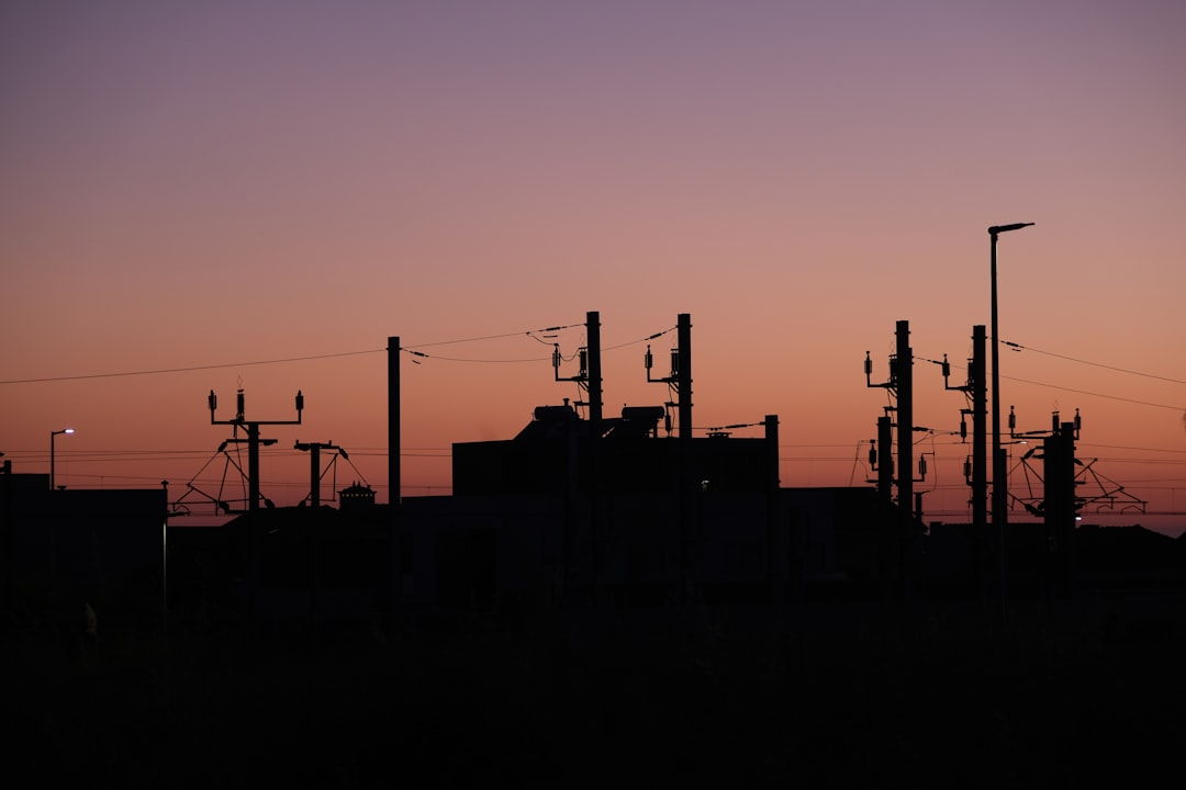 A silhouette of an oil refinery at dusk.